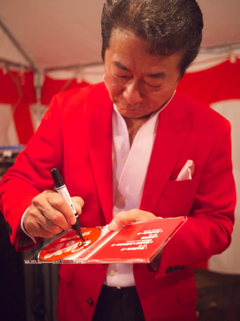 Minami Issei signing a CD for a fan