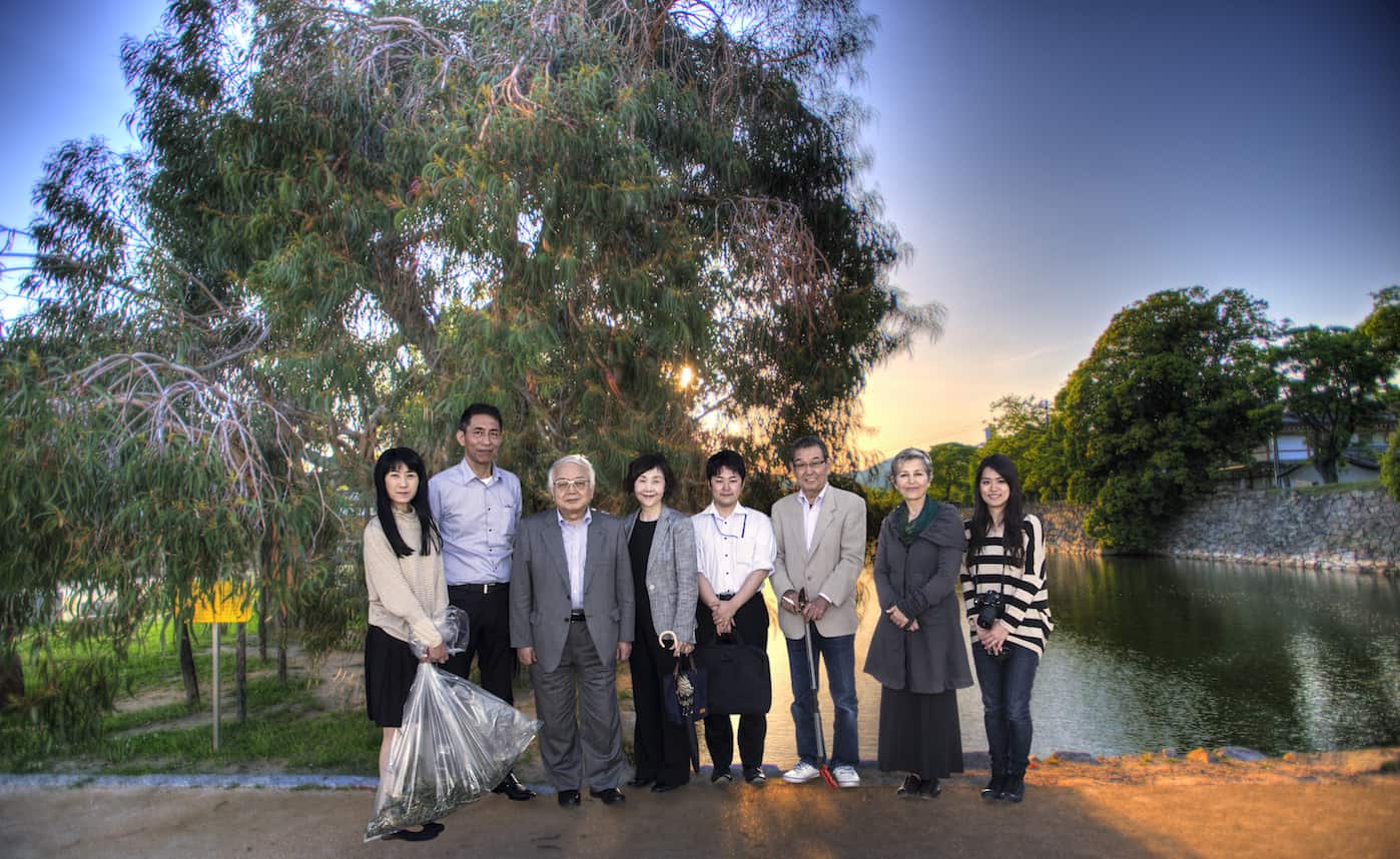 nassrine azzimi and the green legacy team in front an a-bomb survivor tree in the grounds of hiroshima castle in japan